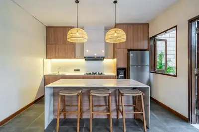 a kitchen with a large island with bar stools at Villa Bettini Stylish 3BR with Pool Near Bintang in Seminyak
