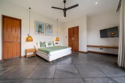 a bedroom with a bed and a flat screen tv at Villa Bettini Stylish 3BR with Pool Near Bintang in Seminyak