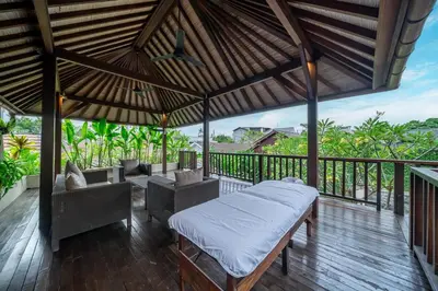 a room with a bed and chairs on a deck at Villa Bettini Stylish 3BR with Pool Near Bintang in Seminyak