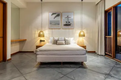 a bedroom with a large bed with two lamps on it at Villa Bettini Stylish 3BR with Pool Near Bintang in Seminyak