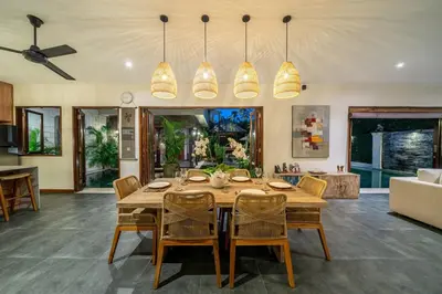 a dining room with a wooden table and chairs at Villa Bettini Stylish 3BR with Pool Near Bintang in Seminyak