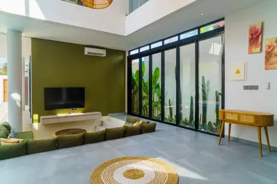 a living room with a couch and a flat screen tv at New 3 Bedroom Villa with rooftop central Seminyak in Seminyak