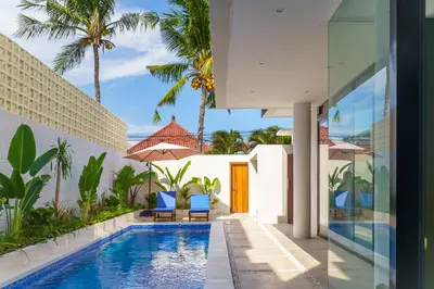 a swimming pool in a villa with palm trees at New 3 Bedroom Villa with rooftop central Seminyak in Seminyak