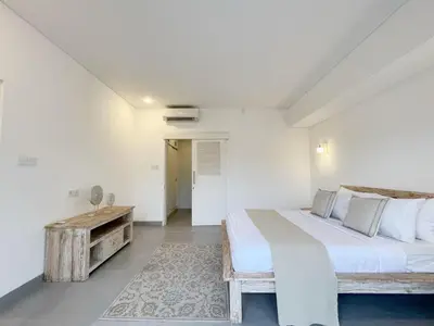 a bedroom with a large bed and a wooden table at New 3BR Orchid Private Pool Villa Seminyak in Seminyak