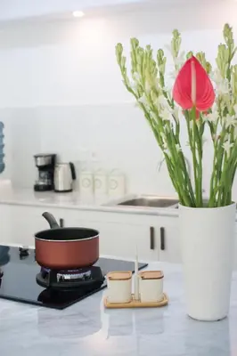 a pot on a stove with a vase with a flower at New 3BR Orchid Private Pool Villa Seminyak in Seminyak
