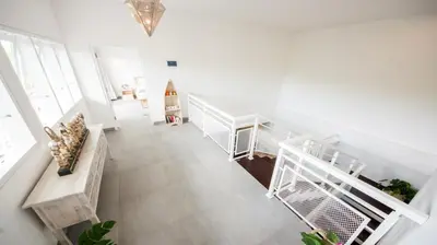 a living room with white walls and a staircase at New 3BR Orchid Private Pool Villa Seminyak in Seminyak