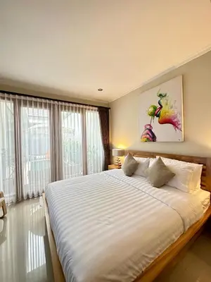 a bedroom with a large bed with white sheets at Villa Karma Damai in Seminyak