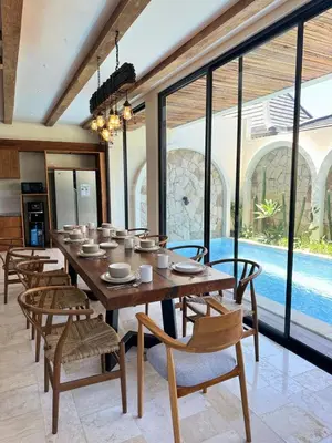 a dining room with a wooden table and chairs at Tuluscoliving Villa Kuta 1, 4 Bedroom & 5 Bathroom in Ngurah Rai International Airport