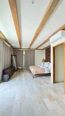 a bedroom with a bed and a table in a room at Tuluscoliving Villa Kuta 1, 4 Bedroom & 5 Bathroom in Ngurah Rai International Airport