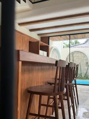 a wooden bar with four chairs around a table at Tuluscoliving Villa Kuta 1, 4 Bedroom & 5 Bathroom in Ngurah Rai International Airport