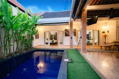 a swimming pool in front of a house at Villa Nagomi in Seminyak