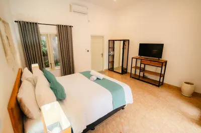 a bedroom with a large bed and a television at Villa Nagomi in Seminyak