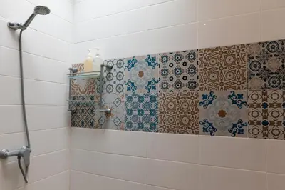 a bathroom with a shower with tiles on the wall at Villa Lima Legian in Seminyak