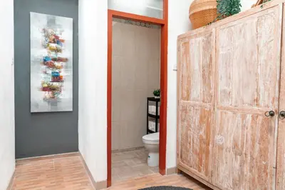 a bathroom with a toilet and a wooden door at Villa Lima Legian in Seminyak