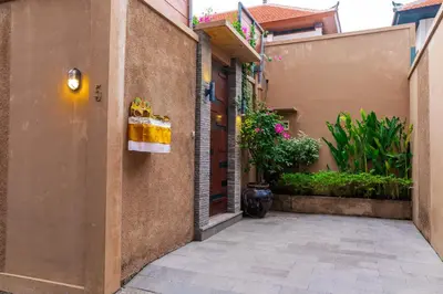 an alley with a building and a door with a towel on it at Villa Lima Legian in Seminyak