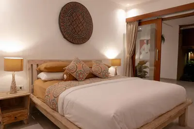 a bedroom with a large bed and a clock on the wall at Villa Lima Legian in Seminyak
