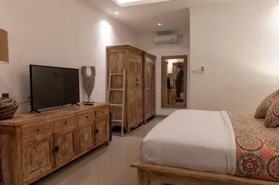 a bedroom with a bed and a flat screen tv at Villa Lima Legian in Seminyak