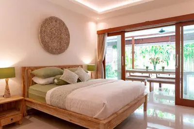 a bedroom with a bed and a large window at Villa Lima Legian in Seminyak