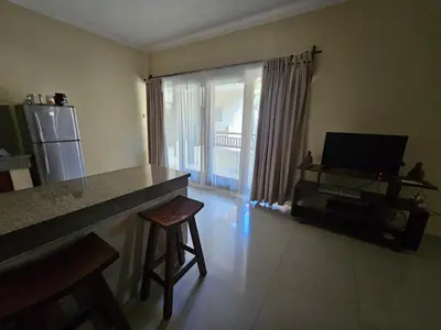 a living room with a counter and a kitchen with a window at Cempaka Apartment Surfaris Inn in Legian
