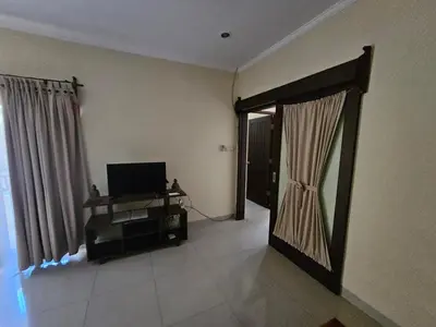 a living room with a television and a door to a room at Cempaka Apartment Surfaris Inn in Legian