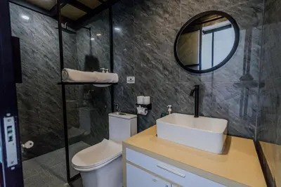 a bathroom with a toilet and a sink and a mirror at Homely Bali at Kayu Aya in Seminyak