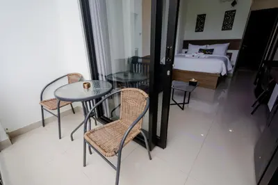 a hotel room with a bed and a table and chairs at Homely Bali at Kayu Aya in Seminyak