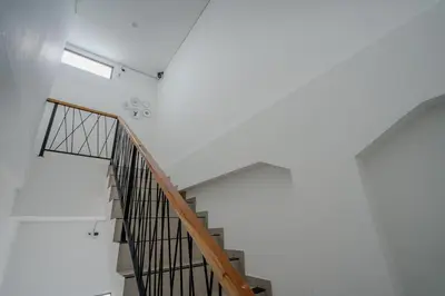 a staircase in a white room with a window at Homely Bali at Kayu Aya in Seminyak