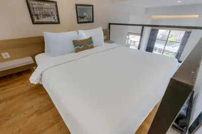 a bedroom with a large white bed in a room at Homely Bali at Kayu Aya in Seminyak