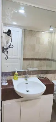 a bathroom with a white sink and a mirror at The Palmana Tropical Garden Jayakarta Residence 36 in Seminyak