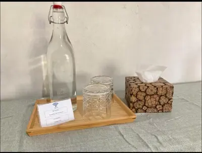 a wooden tray with a bottle and glasses and a box at RBE Hotel Kuta- 5 Min to Airport&Beach by Micky Studio in Ngurah Rai International Airport