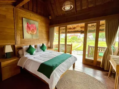 a bedroom with a bed in a room with windows at Uma Padi Cabin Umalas Bali in Kerobokan