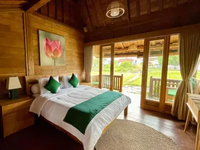 a bedroom with a bed in a room with windows at Uma Padi Cabin Umalas Bali in Kerobokan