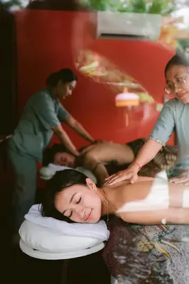 a woman laying on a bed getting a massage at The Suaka Baliaga by Puri Asia in Seminyak
