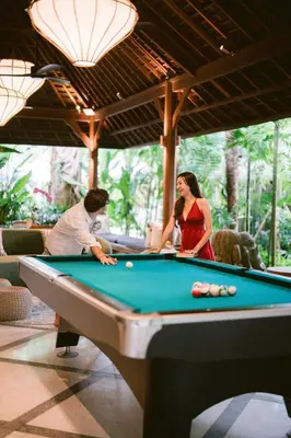 a man and a woman playing a game of pool at The Suaka Baliaga by Puri Asia in Seminyak