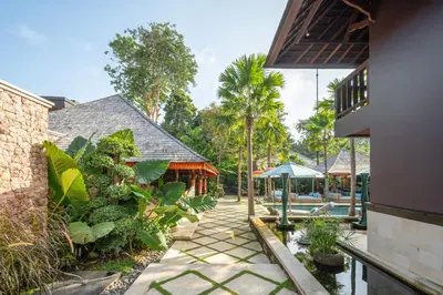 a courtyard of a house with trees and plants at The Suaka Baliaga by Puri Asia in Seminyak