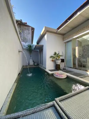 a pool of water in front of a house at Two spacious bedroom villa in Seminyak