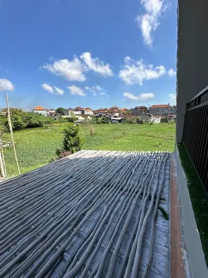 a metal roof on a house with a field at Hustlers paradise in Bali in Kerobokan