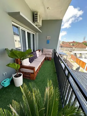 a balcony with a couch and plants on a balcony at Hustlers paradise in Bali in Kerobokan