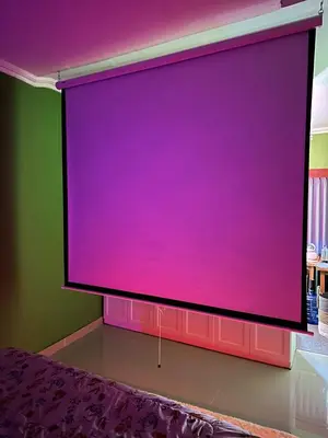 a large screen in a room with a purple wall at Hustlers paradise in Bali in Kerobokan