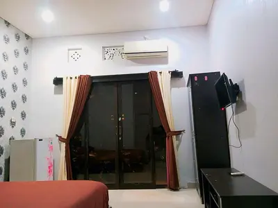 a bedroom with a bed and a television and a window at Room in Pesanggaran in Pesanggaran
