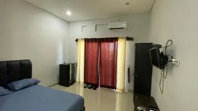 a bedroom with a bed and a window with curtains at Room in Pesanggaran in Pesanggaran