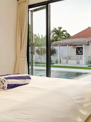 a bedroom with a bed and a swimming pool at Villa Balibiza 3 Kerobokan in Seminyak