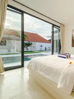 a bedroom with a large bed and a large window at Villa Balibiza 3 Kerobokan in Seminyak