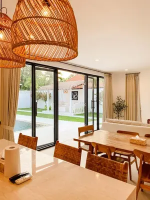 a dining room with a table and chairs and a large window at Villa Balibiza 3 Kerobokan in Seminyak
