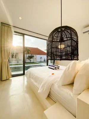 a bedroom with a white bed and a large window at Villa Balibiza 3 Kerobokan in Seminyak
