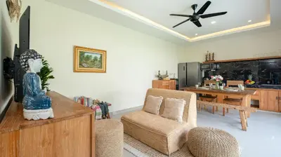 a living room with a ceiling fan and a table at Villa Lange 3 by Villa Finder in Seminyak