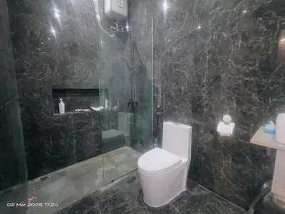 a bathroom with a toilet and a glass shower at Villa Teras Asri Seminyak in Denpasar