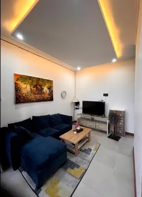 a living room with a blue couch and a table at Villa Teras Asri Seminyak in Denpasar