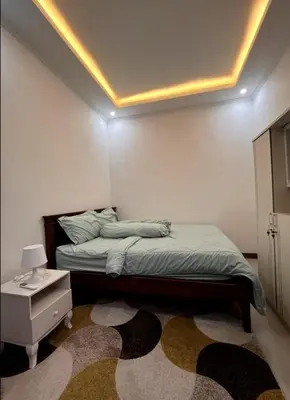 a bedroom with a bed and a table with a lamp at Villa Teras Asri Seminyak in Denpasar