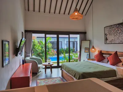 a bedroom with a bed and a view of a pool at Mistral Studio Umalas in Canggu